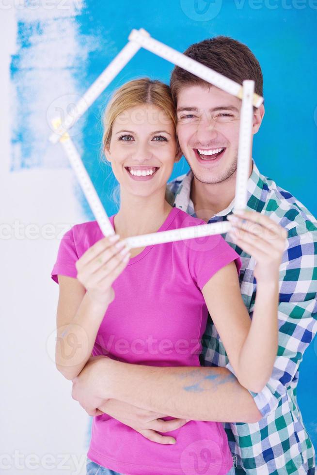 couple heureux peindre un mur dans une nouvelle maison photo