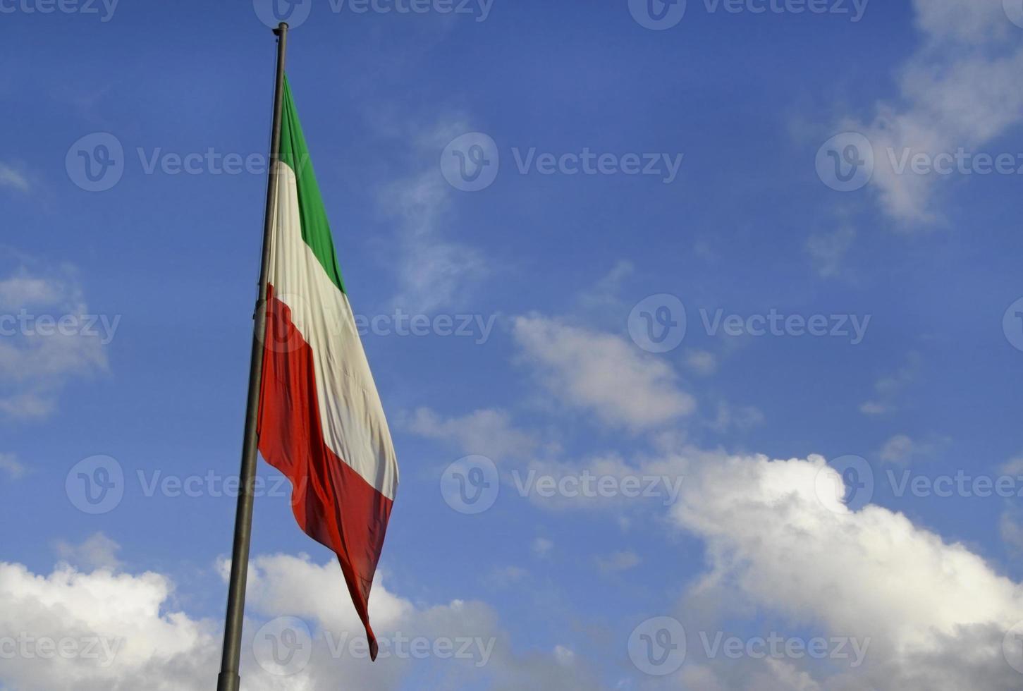drapeau national italien dégonflé contre un ciel bleu photo