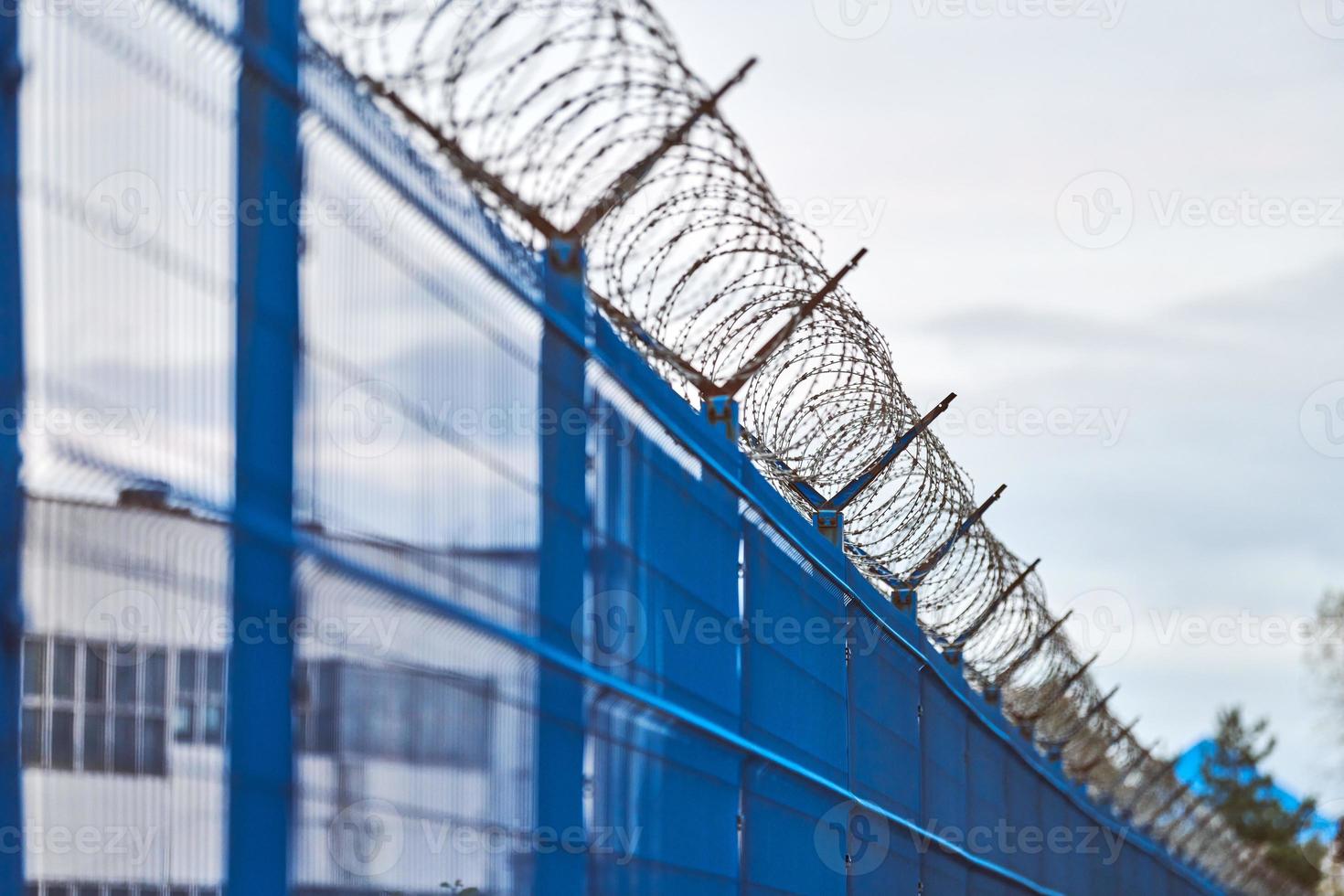 fil de fer barbelé sur la clôture bleue de la zone réglementée photo
