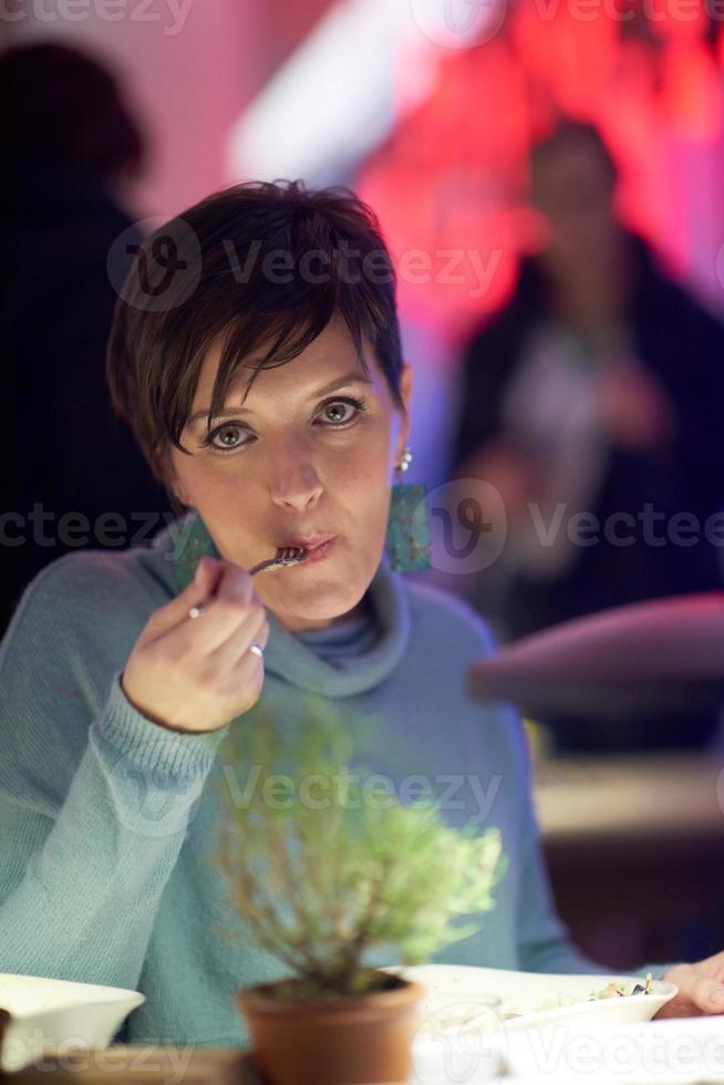 femme mangeant un délicieux dîner dans un restaurant moderne photo