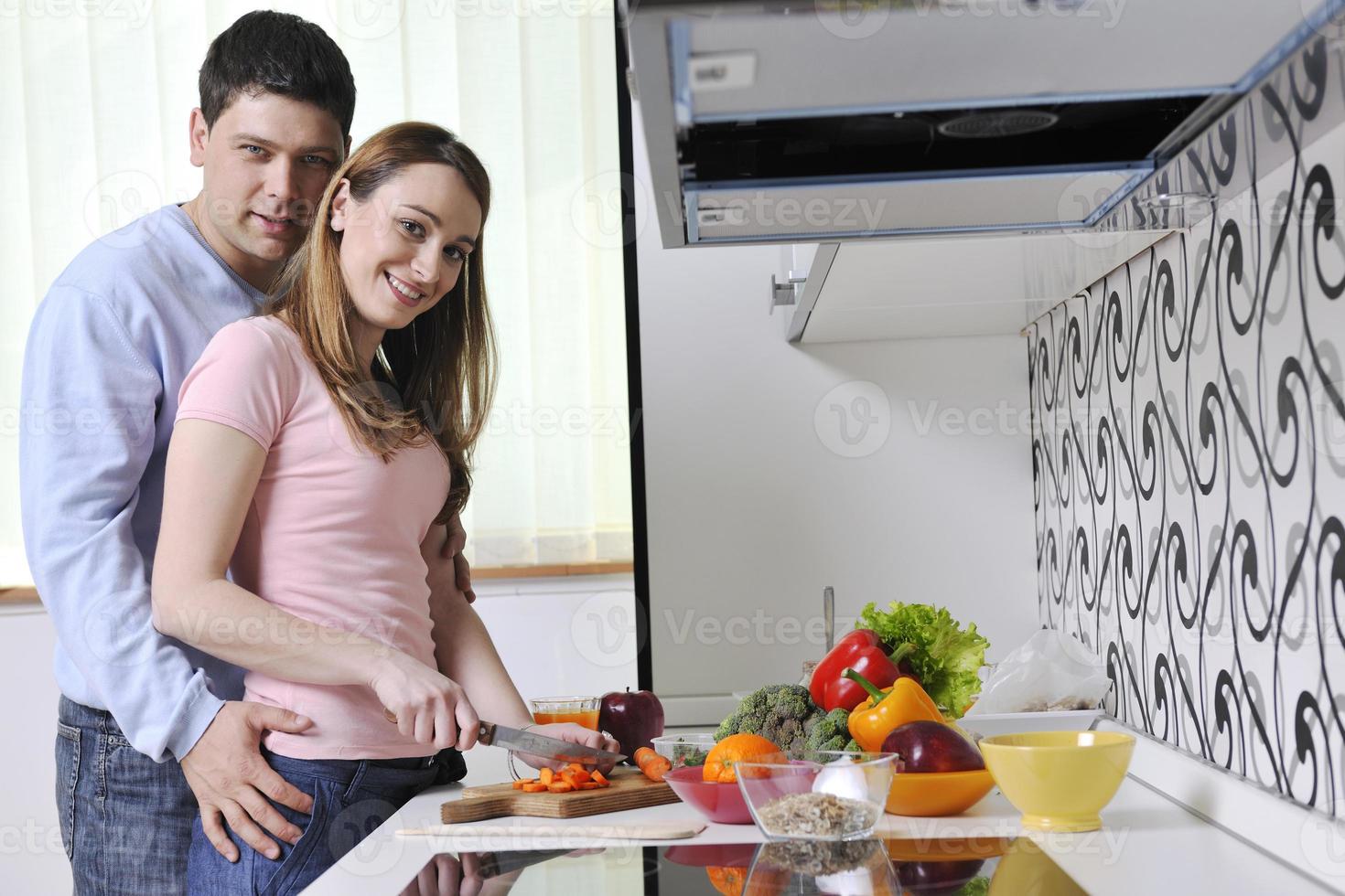 un couple s'amuse et prépare des aliments sains dans la cuisine photo