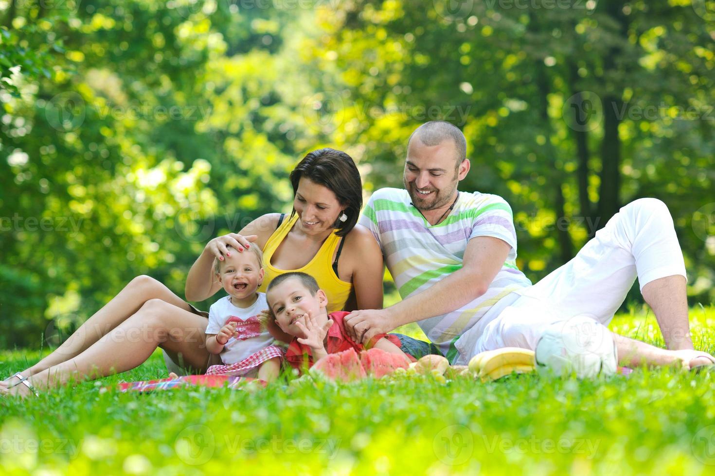 heureux jeune couple avec leurs enfants s'amuser au parc photo