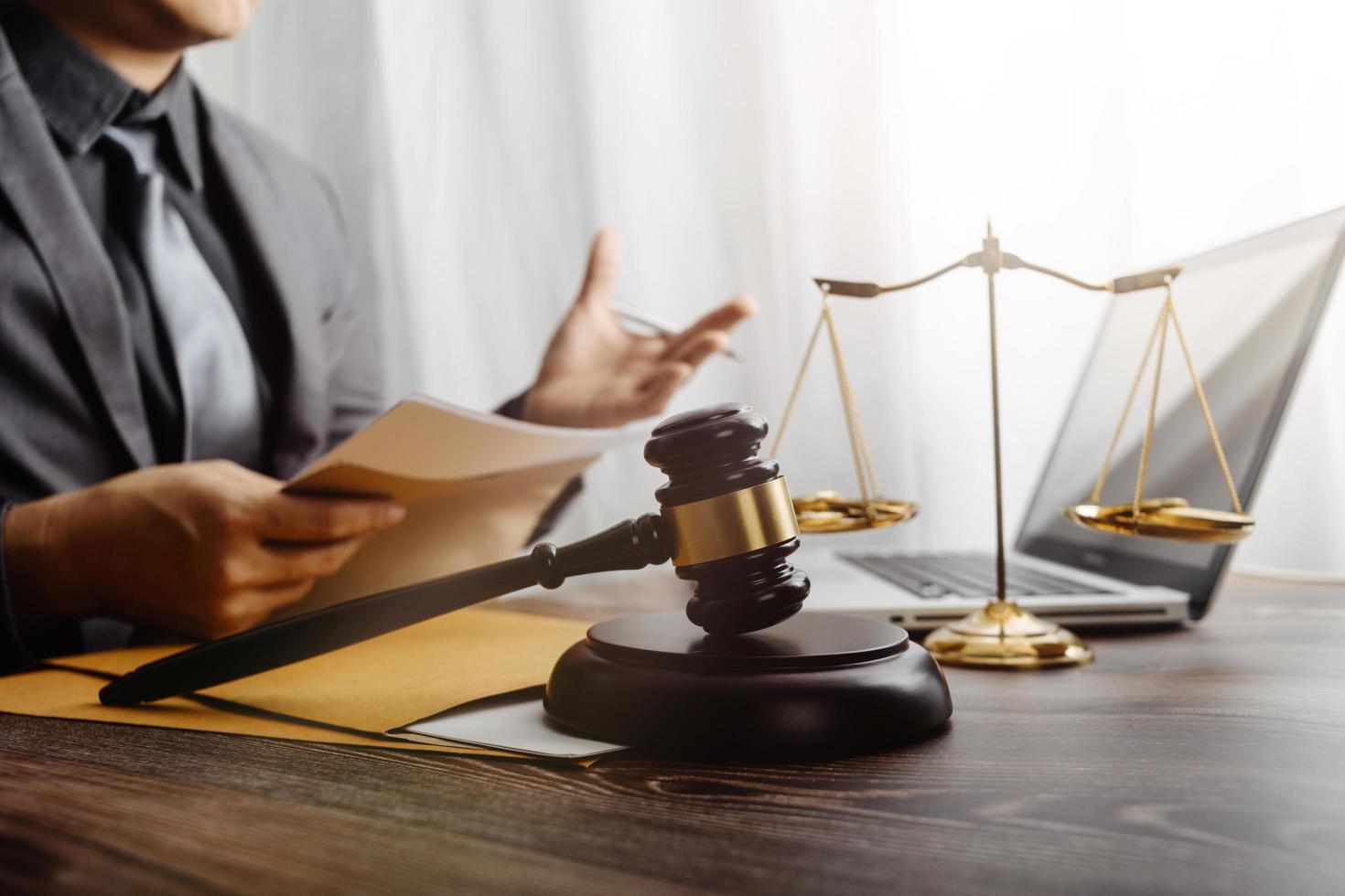 concept de justice et de droit. juge masculin dans une salle d'audience sur une table en bois et conseiller ou avocat masculin travaillant au bureau. concept de droit, de conseil et de justice juridique. photo