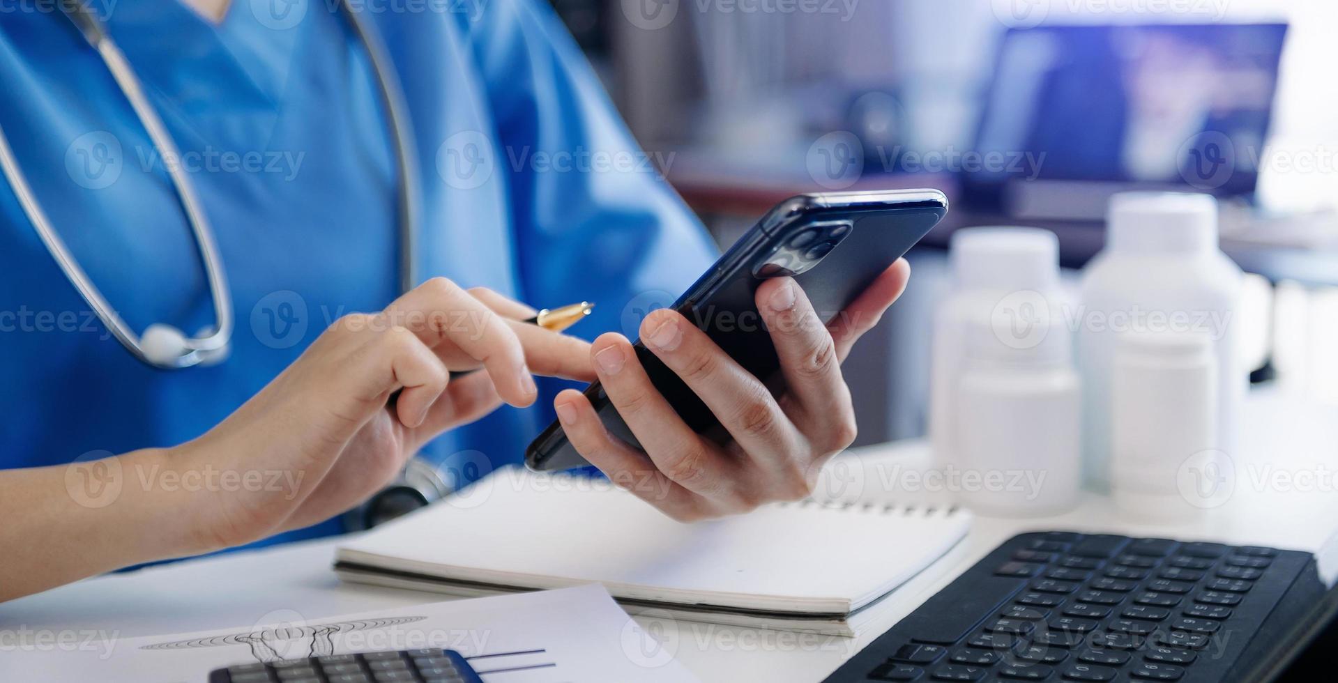 concept de technologie médicale. médecin travaillant avec un smartphone et un stéthoscope au bureau photo