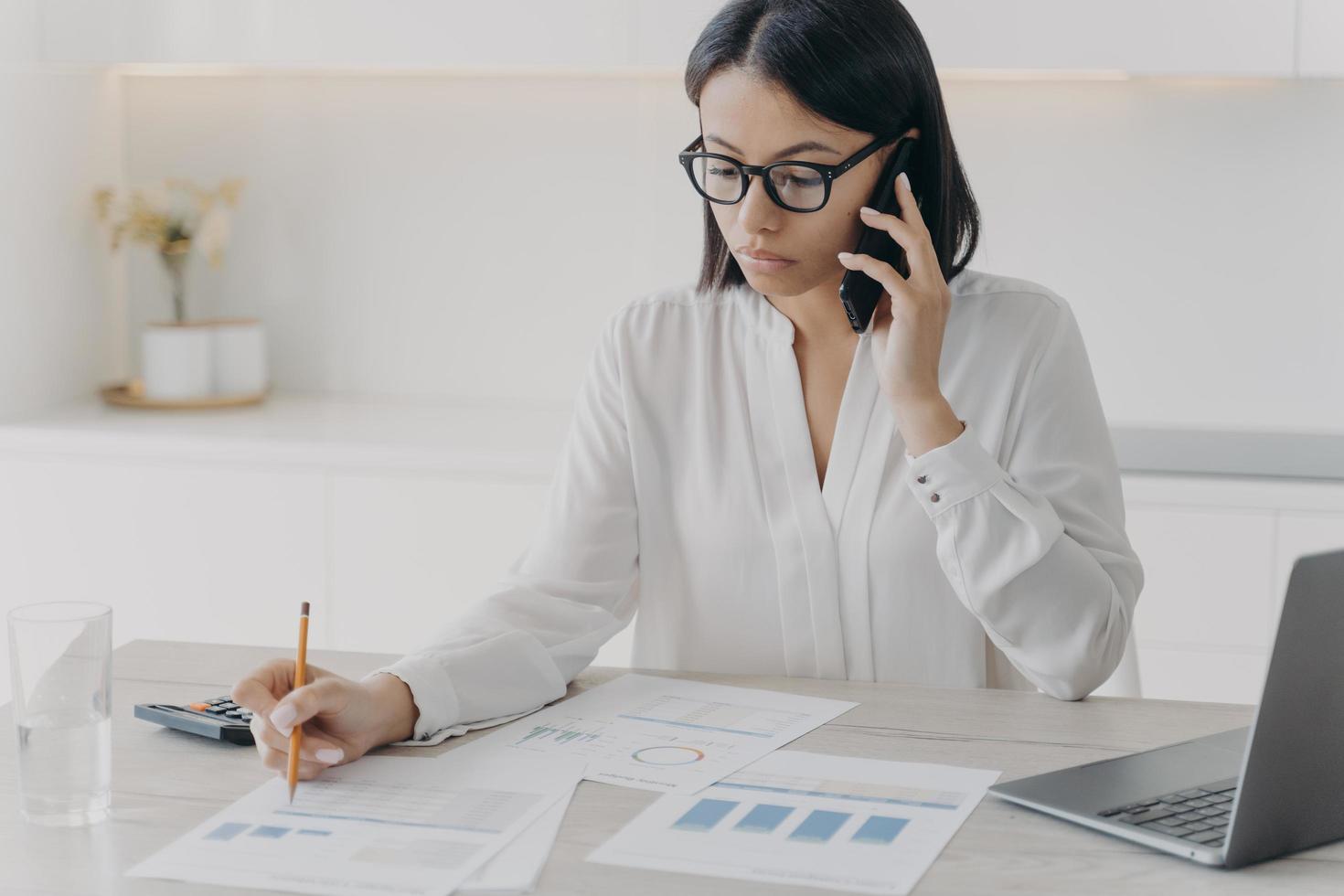 réunion de nomination du secrétaire par téléphone. l'assistant commercial est assis au bureau et fait des recherches. photo