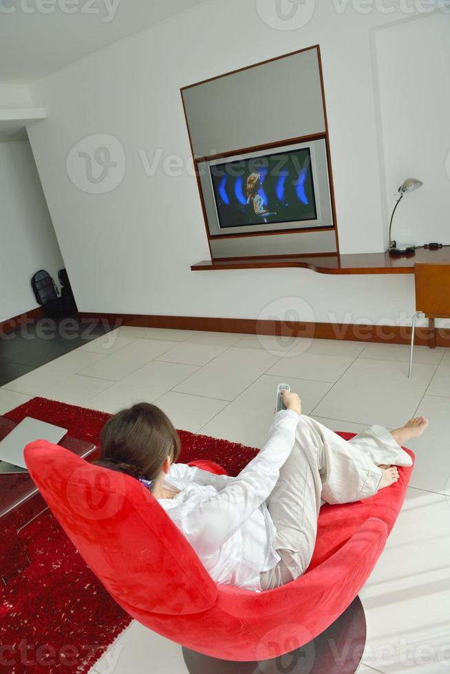 jeune femme regardant la télé à la maison photo