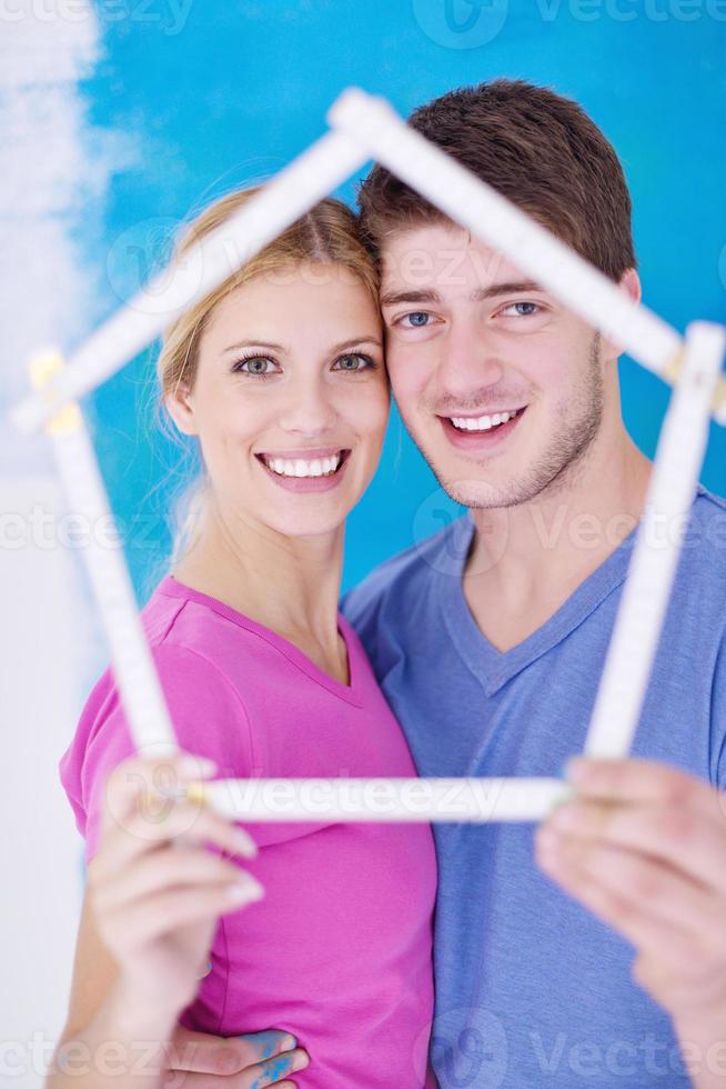 couple heureux peindre un mur dans une nouvelle maison photo