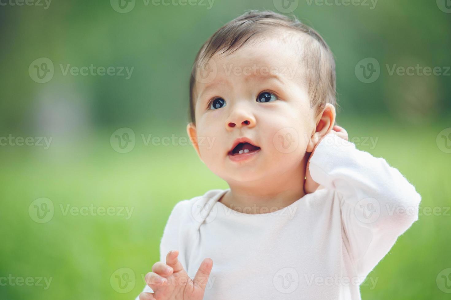 joli bébé asiatique riant dans le jardin photo