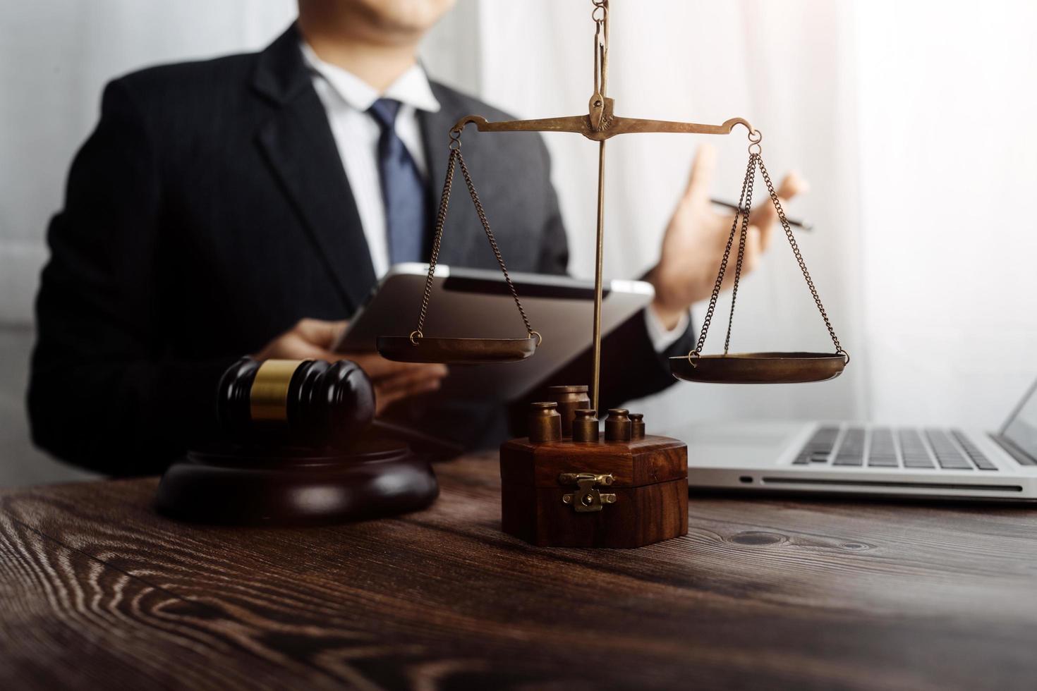 concept de justice et de droit. juge masculin dans une salle d'audience sur une table en bois et conseiller ou avocat masculin travaillant au bureau. concept de droit, de conseil et de justice juridique. photo