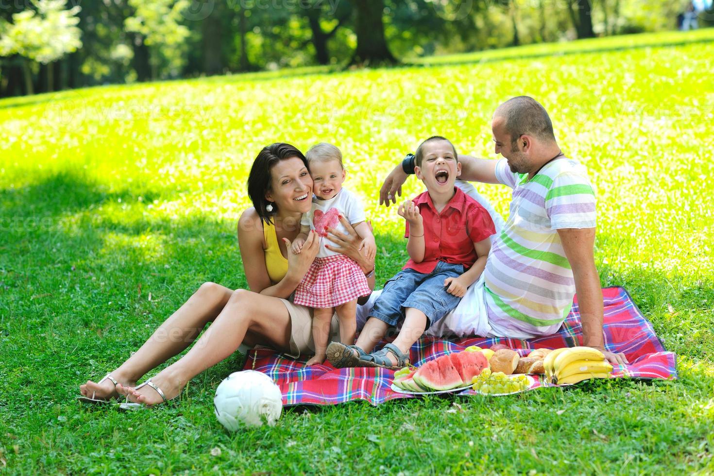 heureux jeune couple avec leurs enfants s'amuser au parc photo