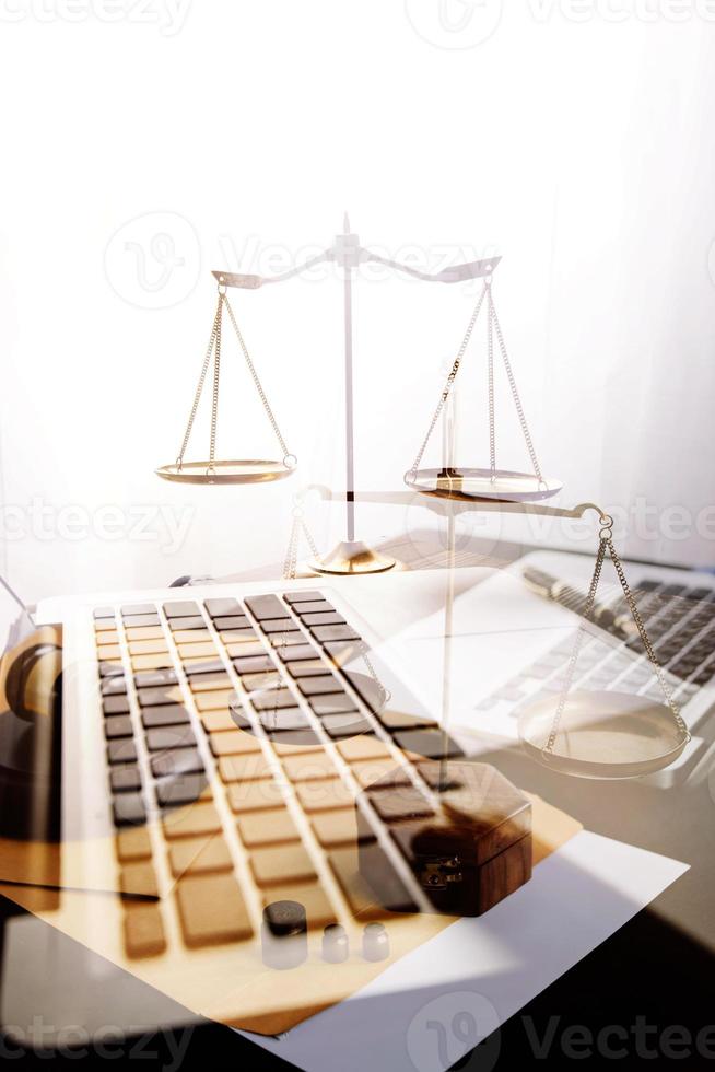 concept de justice et de droit. juge masculin dans une salle d'audience avec le marteau, travaillant avec, clavier d'ordinateur et d'accueil, lunettes, sur table à la lumière du matin photo