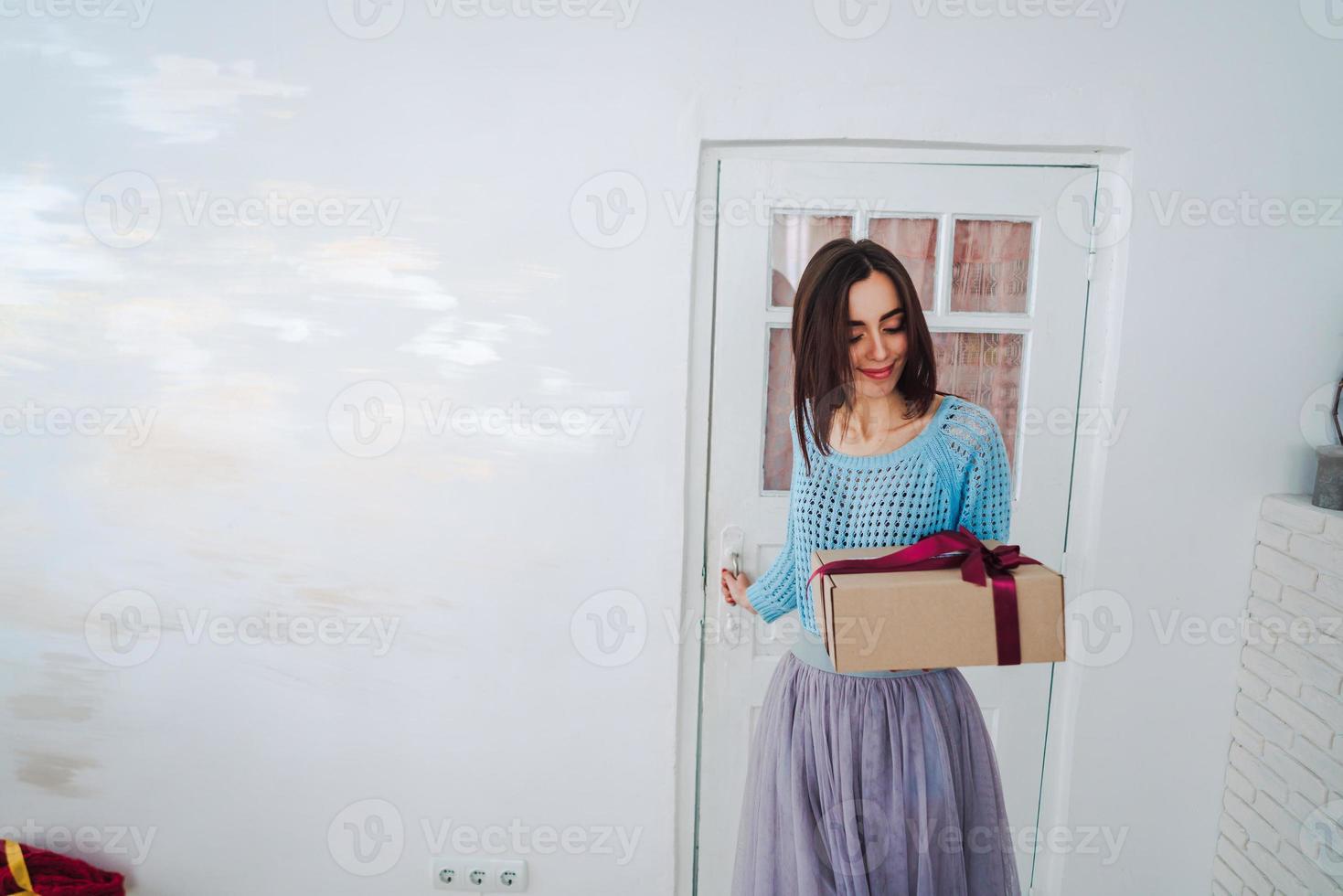 femme tenant une boîte-cadeau de noël dans ses mains photo