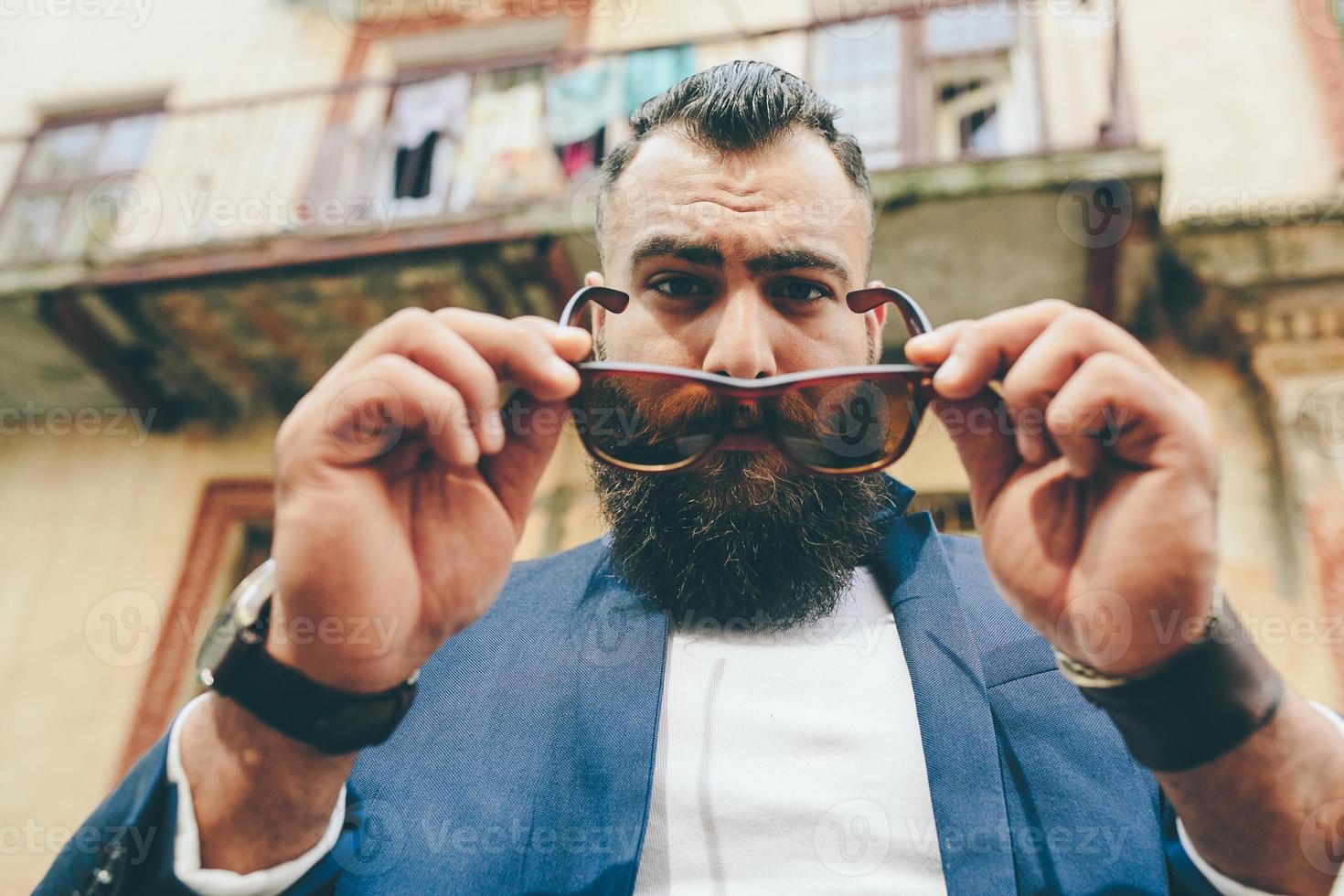 homme barbu cool et élégant enlève ses lunettes photo