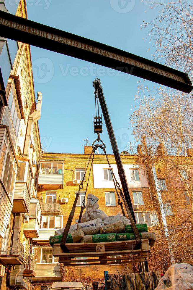 chargement de sacs de sable pour la rénovation d'un appartement dans un immeuble de cinq étages. photo