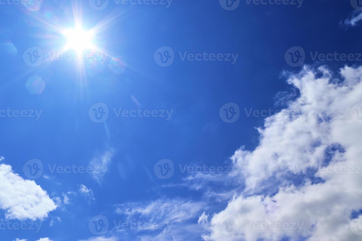 belle vue sur les rayons du soleil avec quelques reflets et nuages dans un ciel bleu photo