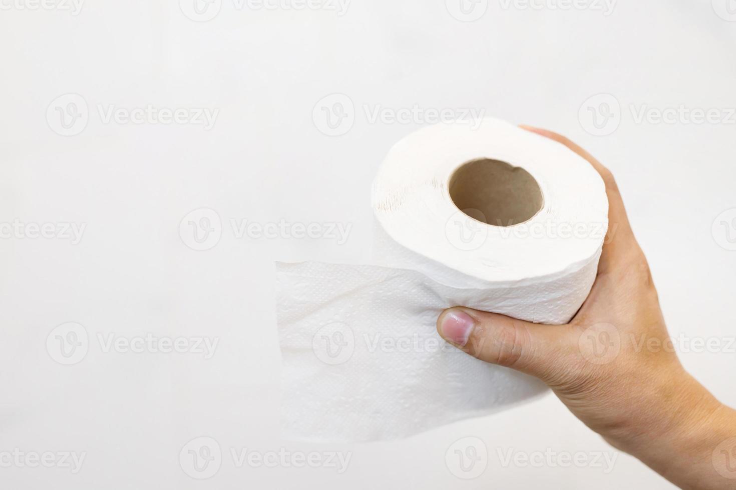 tissu, gros plan d'une main d'homme utilisant le détail d'un seul rouleau de papier toilette propre sur fond blanc, concept de soins de santé d'hygiène. photo