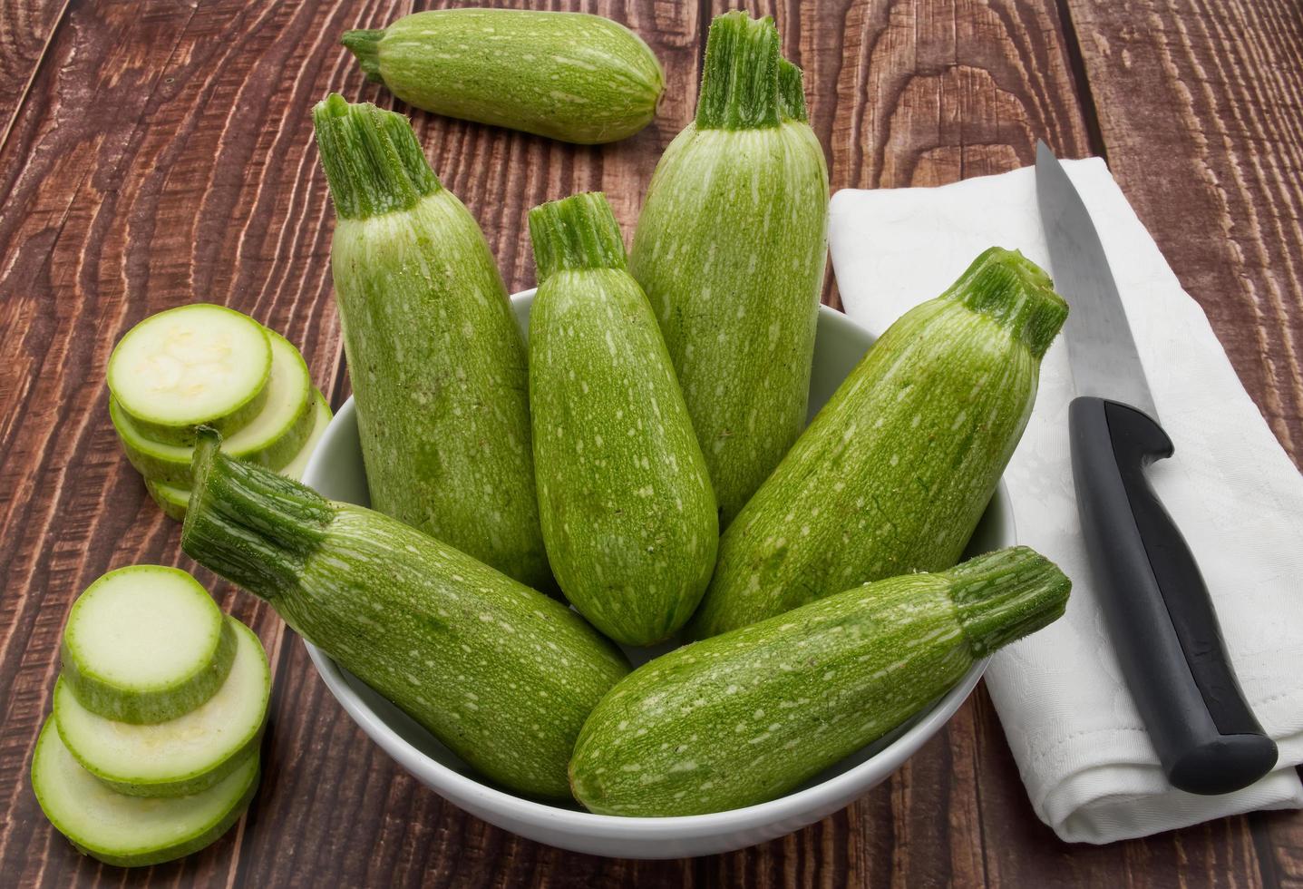 courgettes fraîches crues isolées sur fond de bois. photo