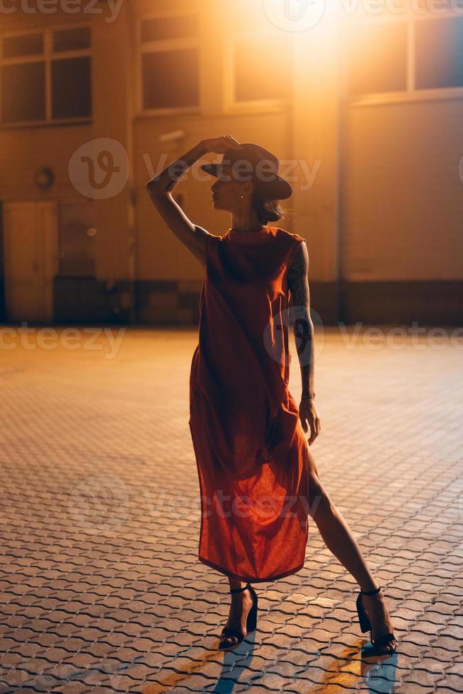 la jeune et jolie fille au chapeau pose devant la caméra la nuit photo