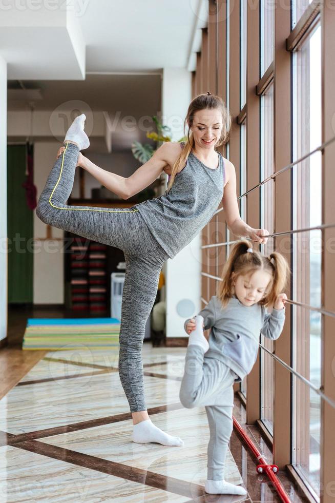 maman et fille effectuent ensemble différents exercices photo