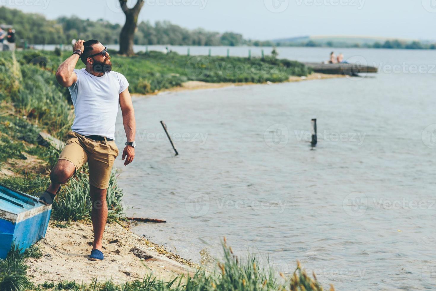 homme barbu américain à l'aide de téléphone près de la rivière photo
