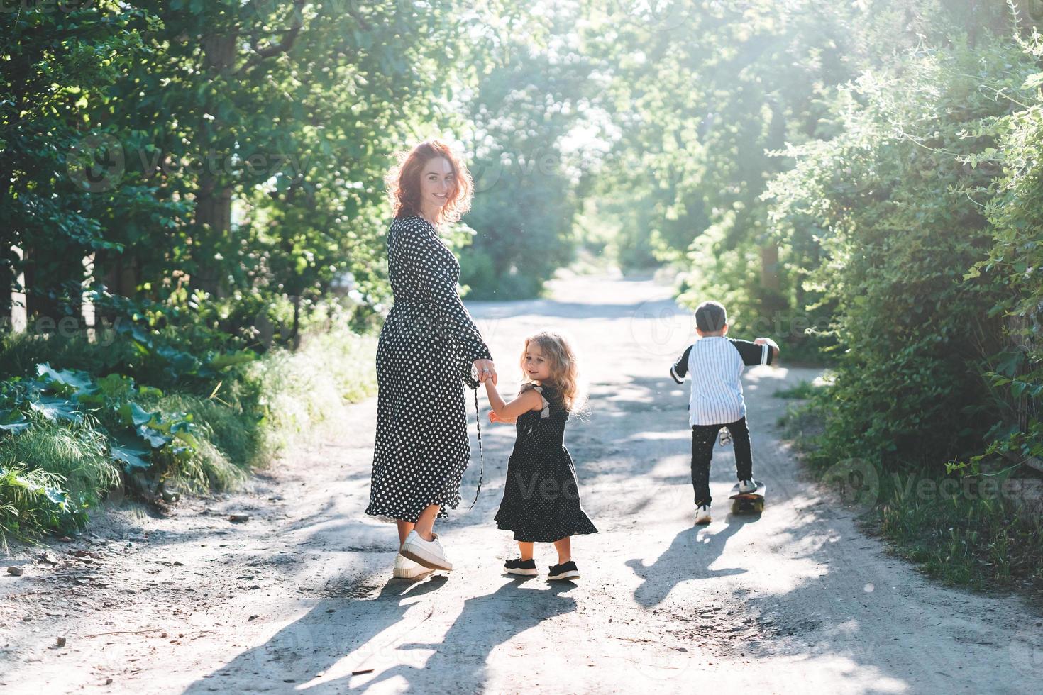 une femme marchant avec ses enfants sur la route photo