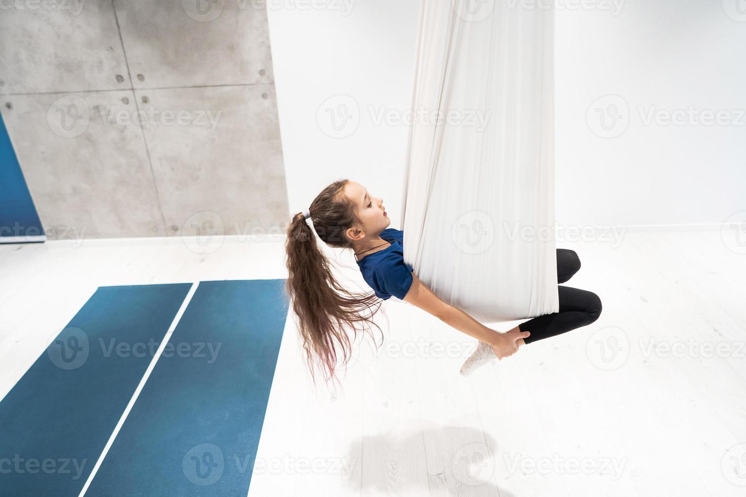 portrait d'une belle jeune fille engagée dans le yoga à la mouche sur des toiles. photo