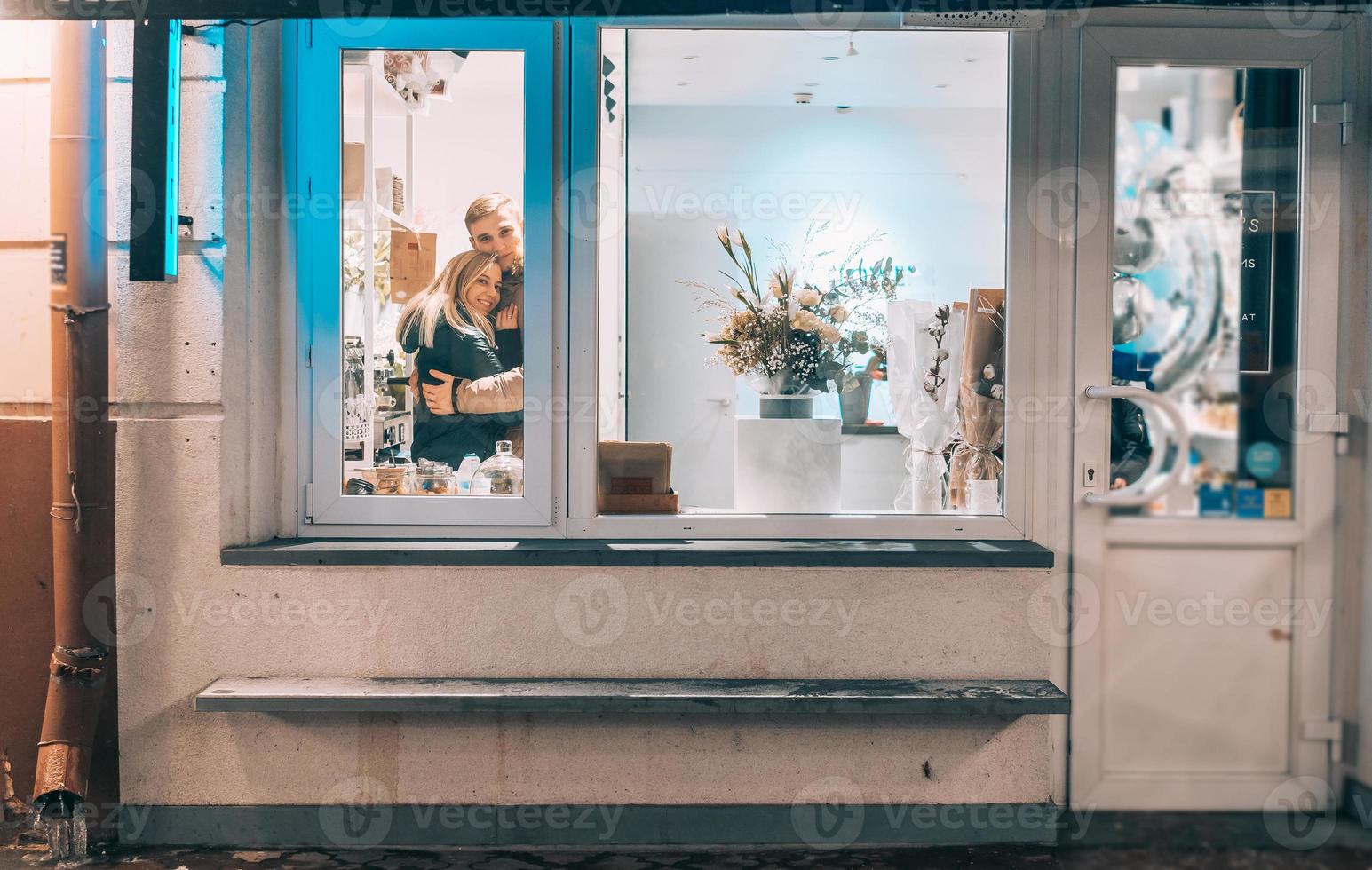 photo à travers la fenêtre. jeune couple au café avec un intérieur élégant