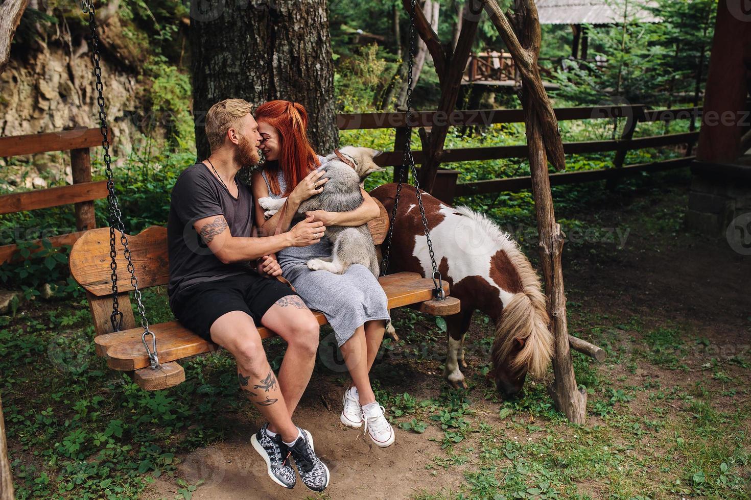 beau couple avec chien sur une balançoire photo