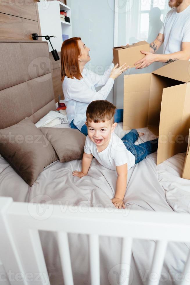 papa maman et petit fils jouent dans la chambre avec des boîtes en papier photo