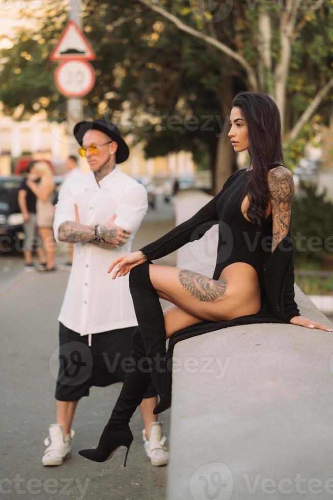 un jeune couple d'amoureux sexy pose devant un appareil photo dans la rue