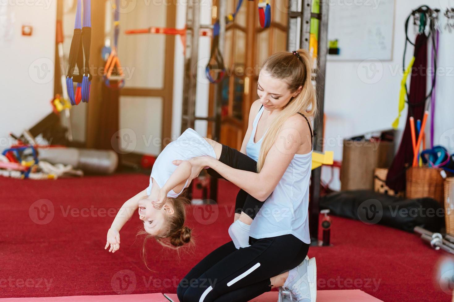 maman et fille effectuent ensemble différents exercices photo