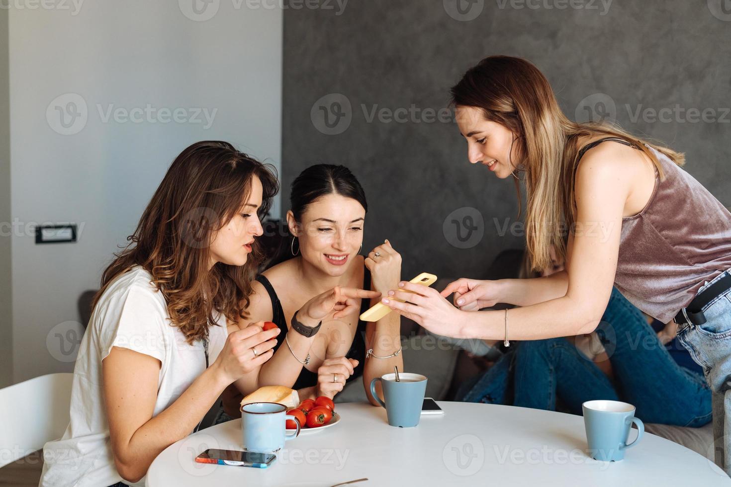 Trois amies petit-déjeuner dans la cuisine photo