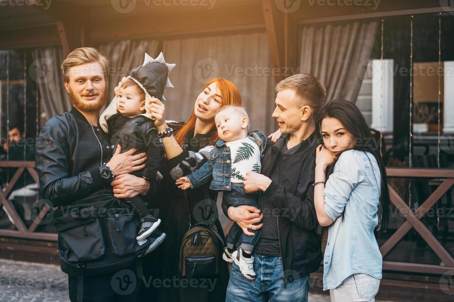 deux familles avec enfants posant devant la caméra photo