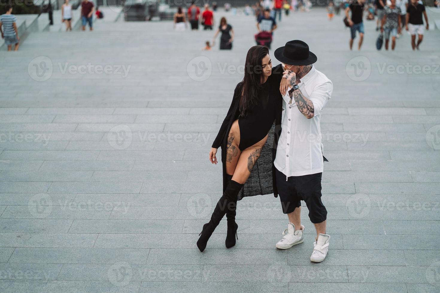 un jeune couple d'amoureux sexy pose devant un appareil photo dans la rue