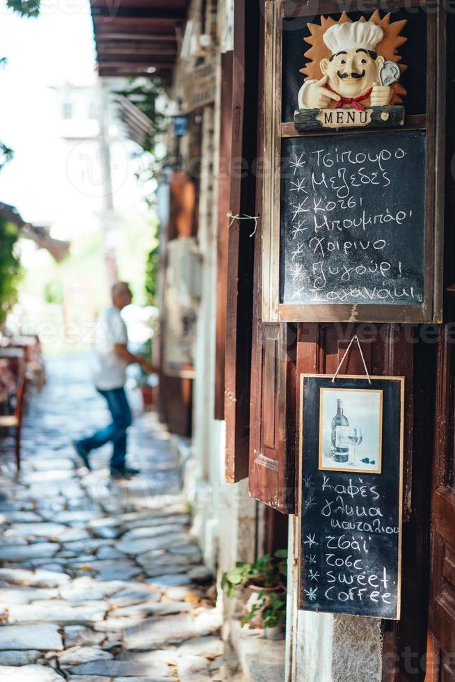 un vieux café grec. assiette en bois avec un menu. photo