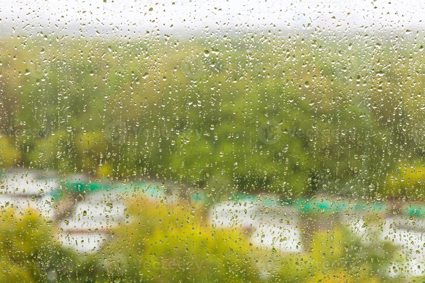 gouttes de pluie sur verre o et jardin de ville flou photo