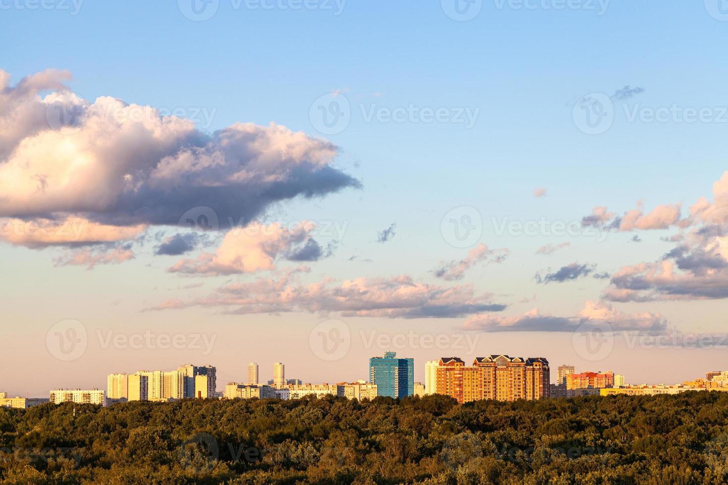 coucher de soleil ciel bleu et rose sur la ville et la forêt photo