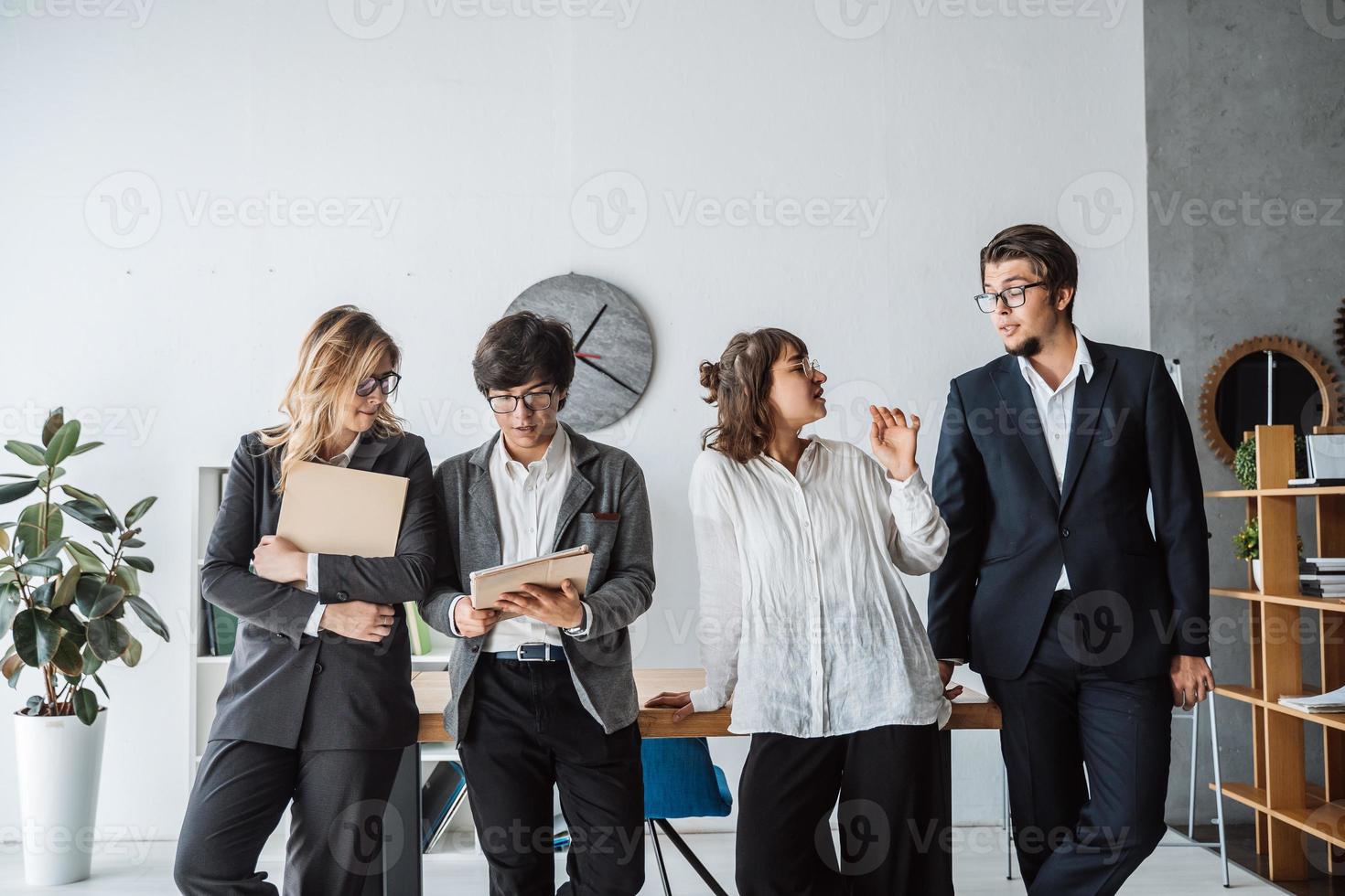 les gens d'affaires debout dans le bureau discutent photo