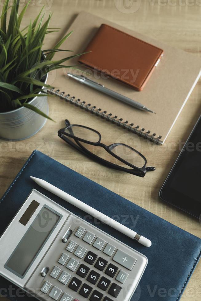 bureau à domicile sur le lieu de travail. vue de dessus de table, ordinateur portable, verre, documents, tablette, carte de visite, sac à main, calculatrice, stylo, livres, café. expérience en affaires, organisation. photo