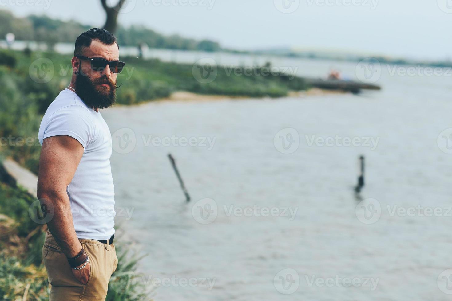 homme barbu américain regarde sur la rive du fleuve photo