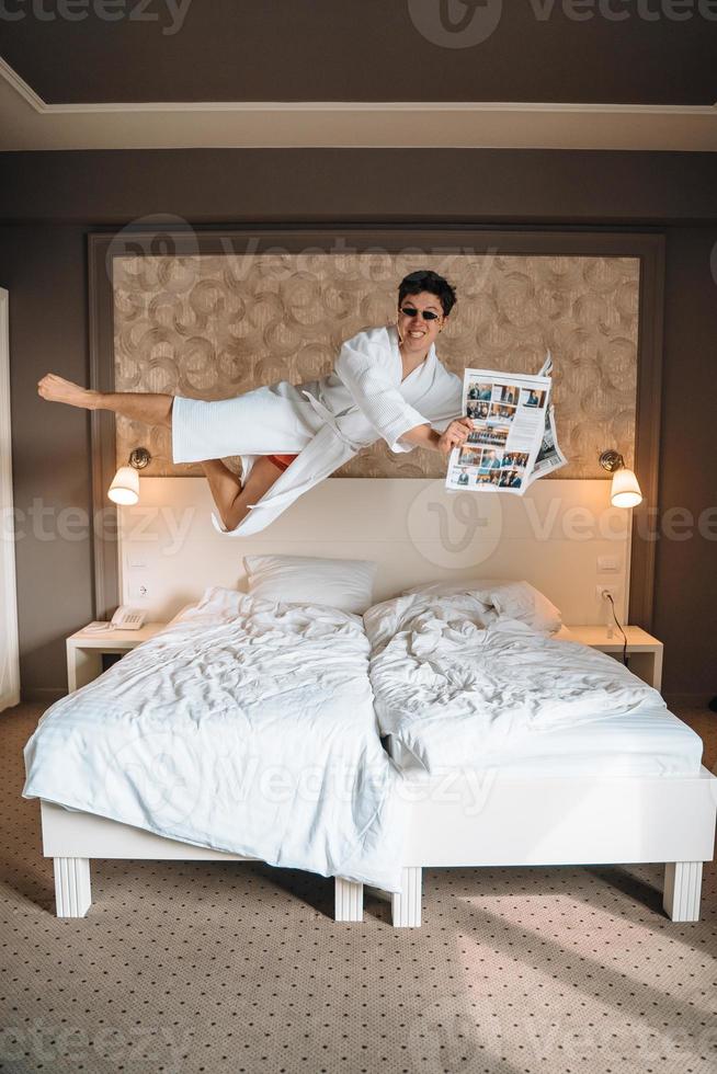 gars avec des lunettes de soleil et un journal haut dans l'air. photo