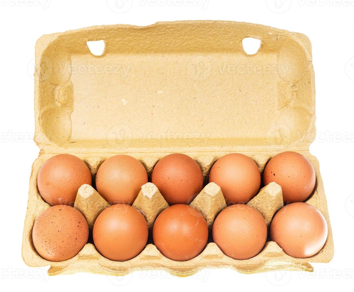 Dix œufs de poule bruns dans une boîte jaune isolée photo