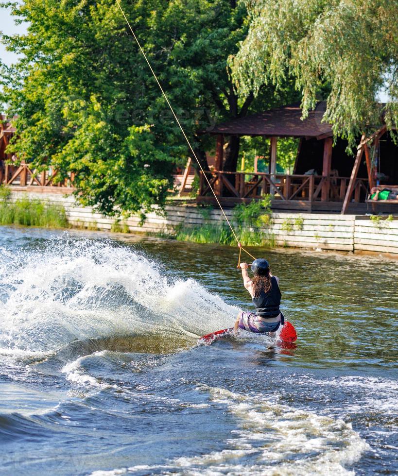 virage raide d'un wakeboarder sur une surface de rivière d'eau dans un parc sportif un jour d'été. photo