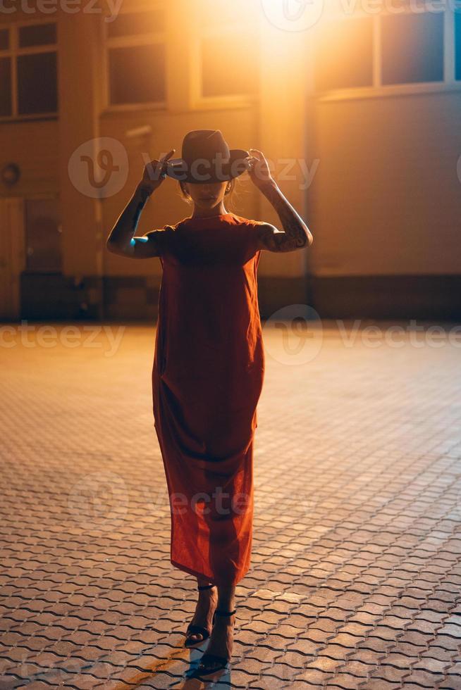 la jeune et jolie fille au chapeau pose devant la caméra la nuit photo