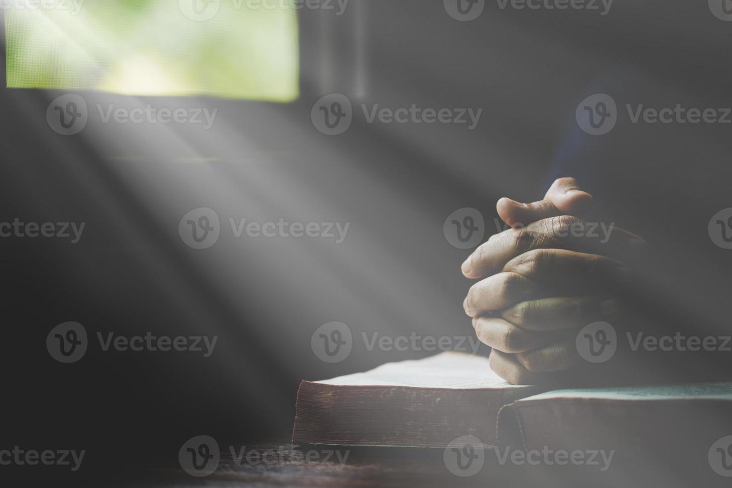 main pliée en prière à dieu sur le livre de la sainte bible dans le concept d'église pour la foi, la spiritualité et la religion, femme priant sur la sainte bible le matin. main de femme catholique chrétienne avec culte biblique. photo