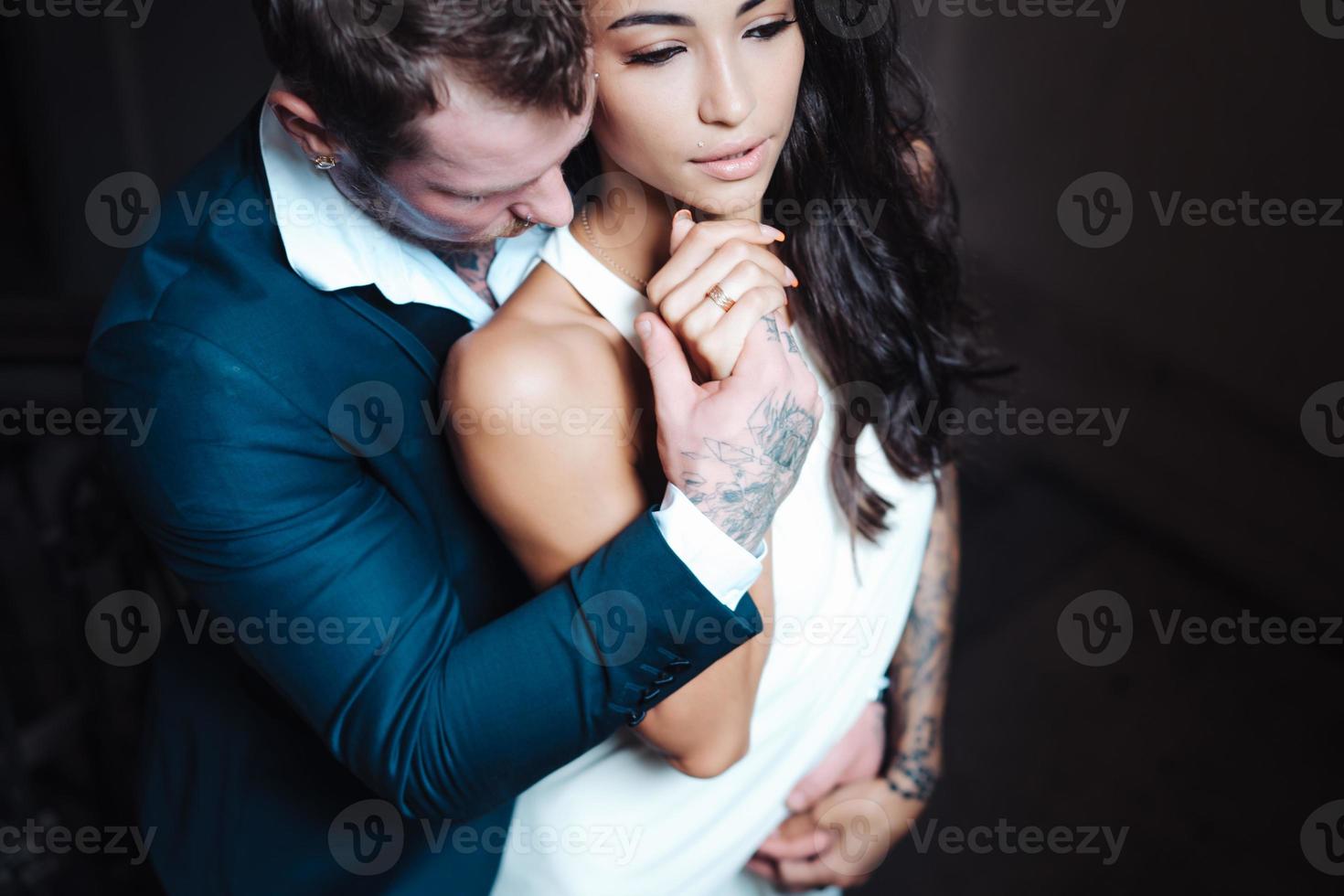 beau, jeune couple posant devant la caméra à l'intérieur photo