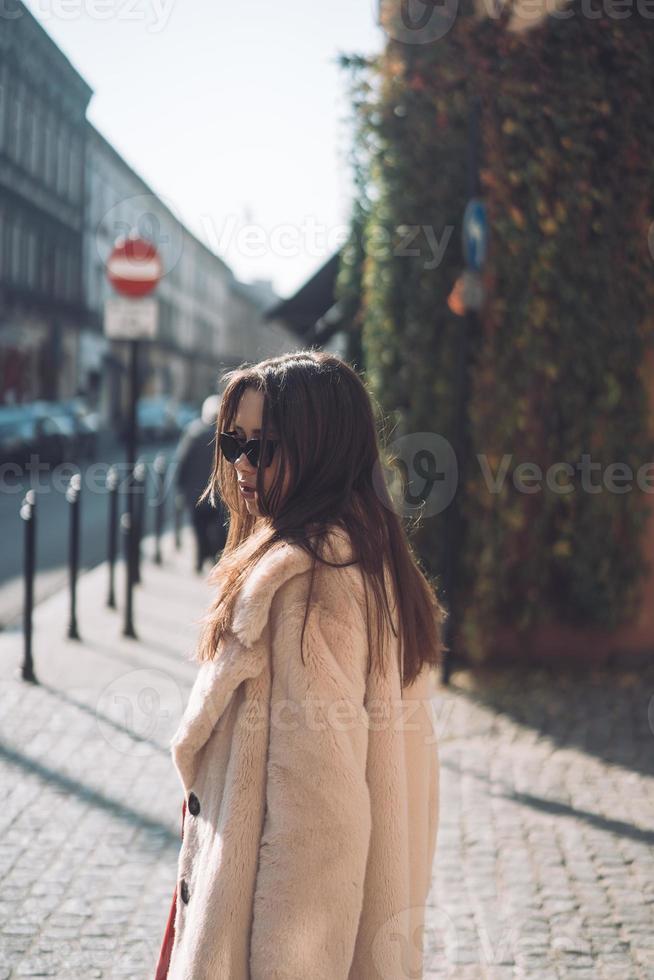 belle jeune femme élégante marchant en manteau rose photo