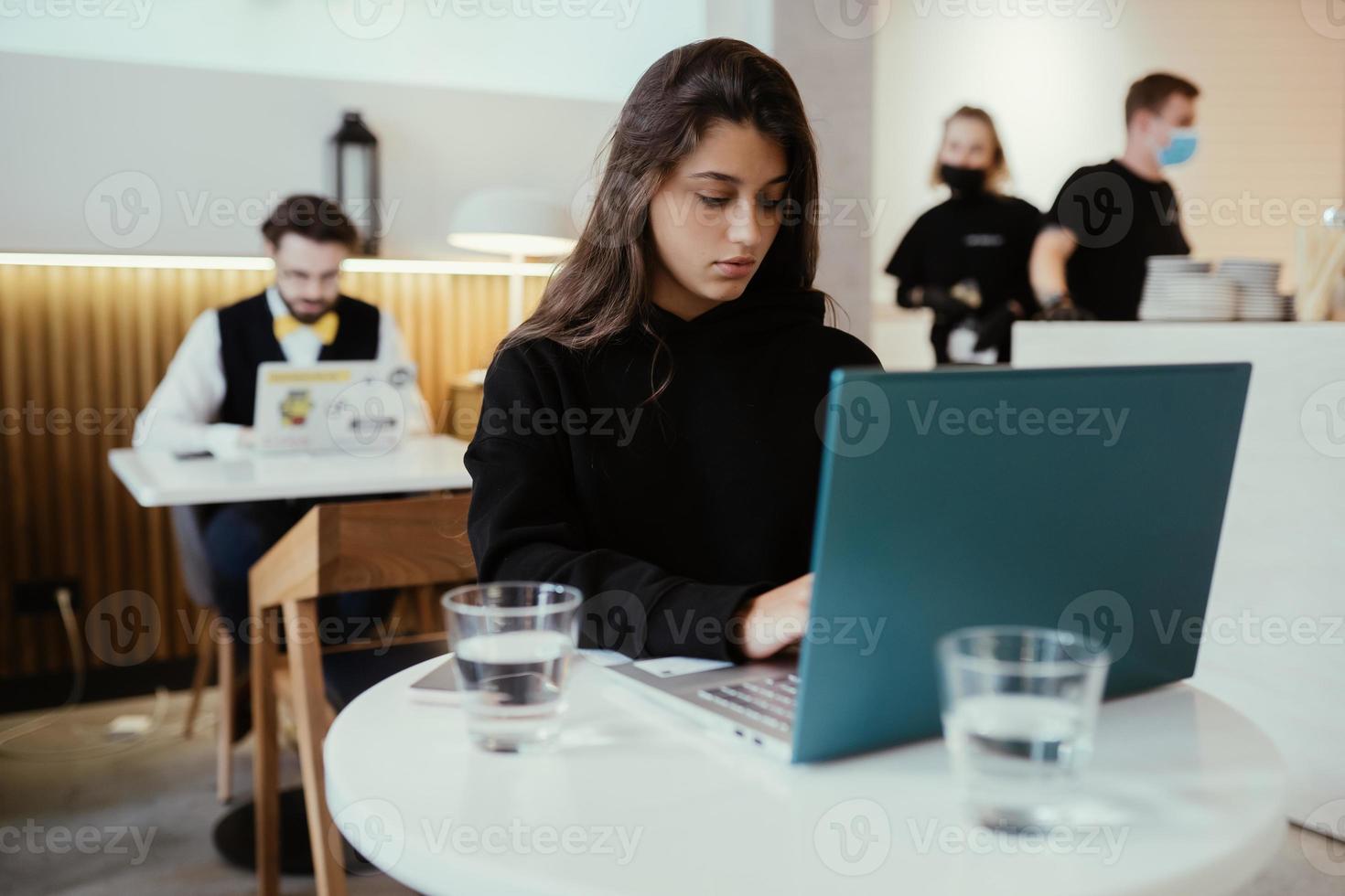 portrait d'une étudiante utilisant un net-book assis dans un café photo