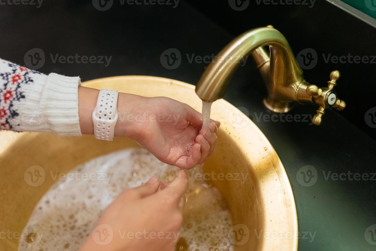 photo en gros plan d'une femme se lave les mains avec de l'eau et du savon.