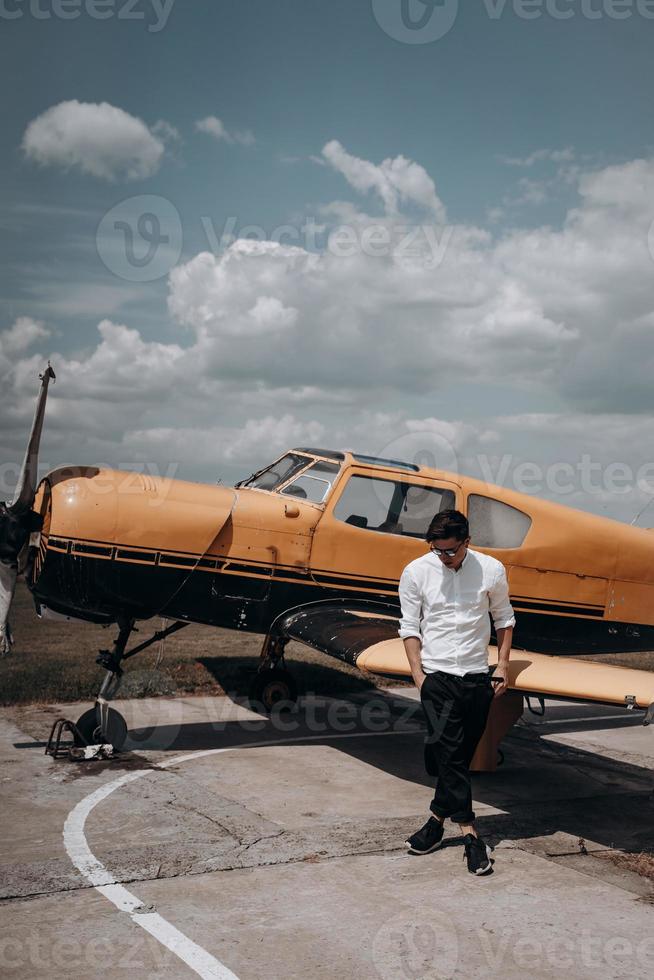 un homme debout sur le fond d'un petit avion monomoteur. photo